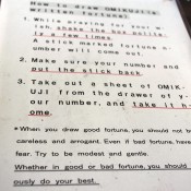 Omikuji fortune instructions at Sensoji Temple in Tokyo. Photo by alphacityguides.